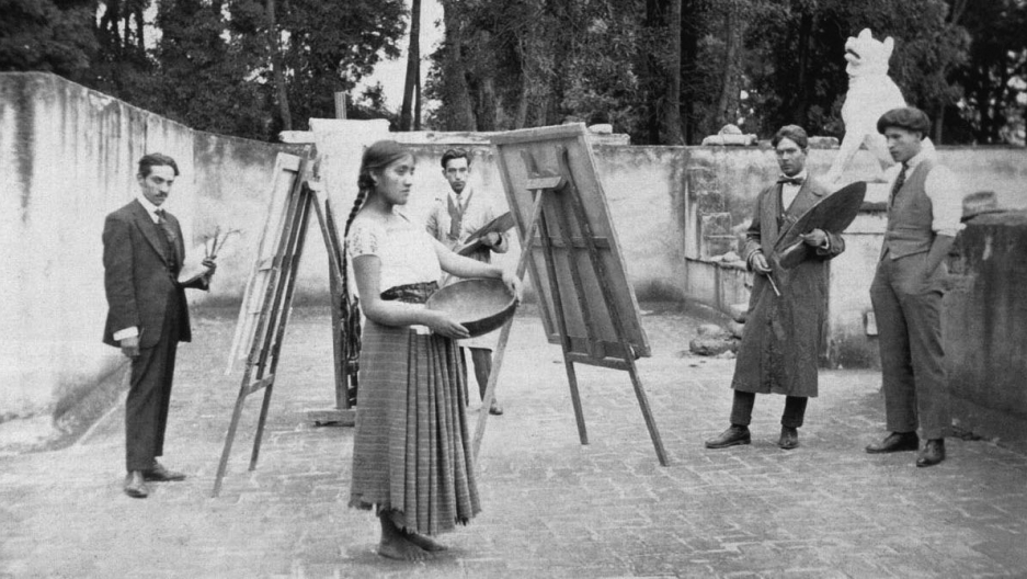 [Description: Luz Jiménez, Nahua, poses at the Escuela de Pintura al Aire Libre de Coyoacán, 1922. From left to right: Ramón Alva de la Canal, model Luz Jiménez, Fernando Leal, Francisco Díaz de León, Enrique A. Ugarte. Image of an unidentified author, taken from the book “Escuelas de pintura al aire libre. Episodios dramáticos del arte en México